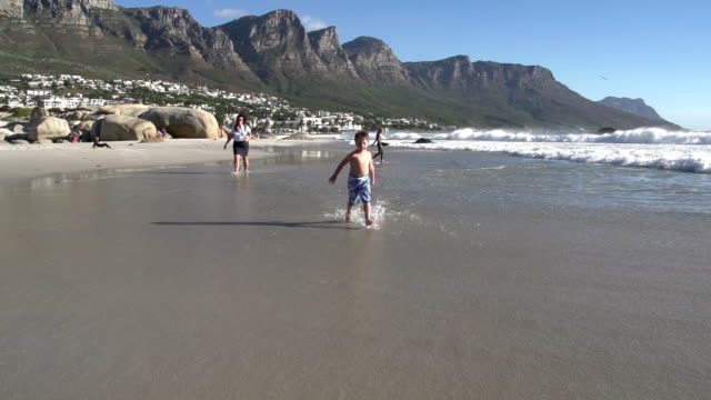 Slow-motion-of-young-boy-running-towards-the-camera-along-the-beach,South-Africa