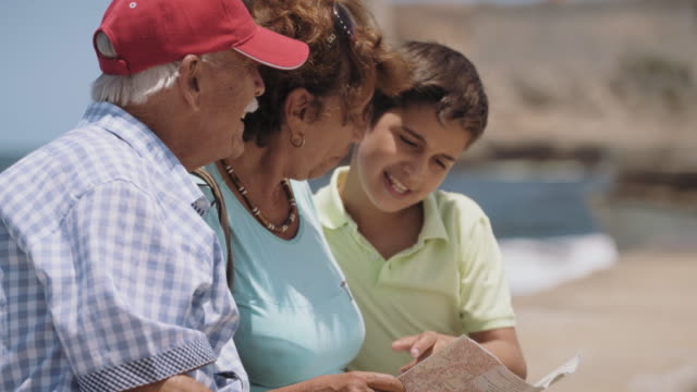 Familie-mit-Großeltern-und-junge-auf-Urlaub-Im-Kuba-Lesung-touristischen-Landkarte
