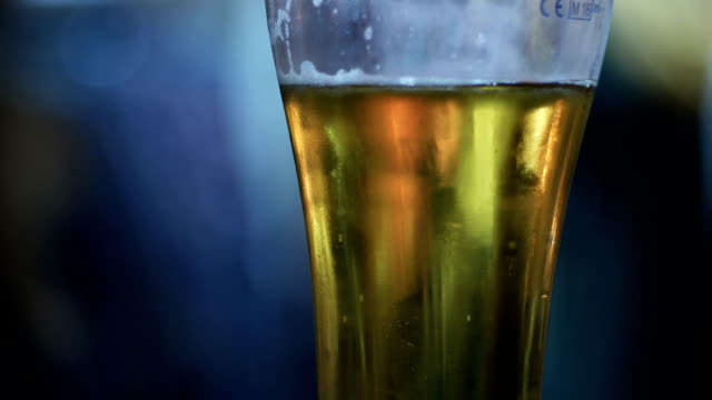 Bierglas-in-einem-Pub.-Halb-betrunken-Glas-Bier-mit-einem-Schwerpunkt-Personen-Hintergrund.