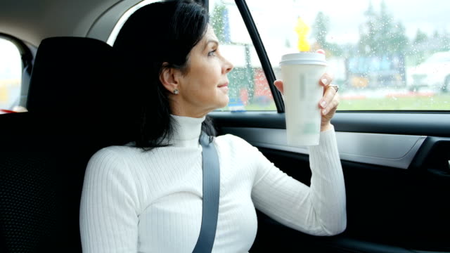 Frau-sitzt-im-Auto-halten-Einweg-Tasse
