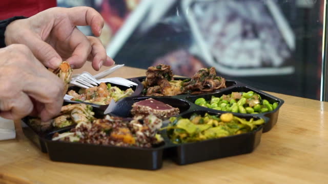 Hand-Essen-kaltes-Gericht-Meeresfrüchten-und-Salat-Teller-in-Europa-offenen-Markt-in-Zeitlupe-gedreht-120-fps
