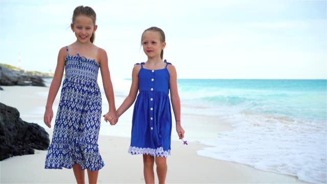 Zwei-kleine-Schwestern-walking-am-Meer-am-weißen-Strand