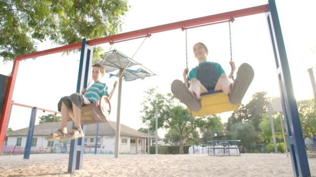 Kinder-schwingen-zusammen-auf-einem-öffentlichen-Spielplatz