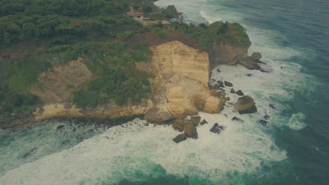Fuertes-olas-golpeando-las-rocas-grandes-en-la-playa-de-barón,-Yogyakarta,-Indonesia
