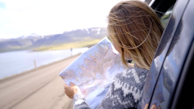Junge-Frau-im-Auto-Blick-auf-Karte,-Road-Trip-Konzept-Urlaub