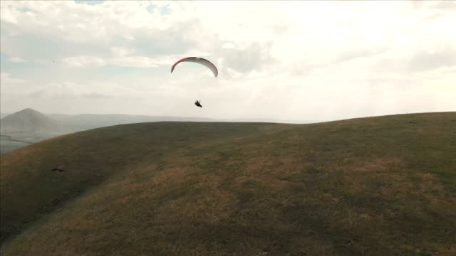 Atleta-paraglider-vuela-en-su-parapente-junto-a-las-golondrinas.-Seguimiento-desde-los-aviones-no-tripulados