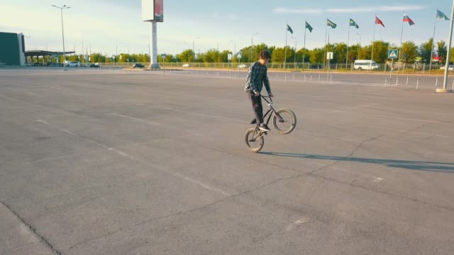 fliegende-Kamera-Junge-männliche-Jugendliche-Reiter-auf-dem-bmx-Rad-auf-der-leeren-städtischen-Stelle,-die-keine-Menschen-asphalt