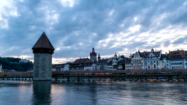 Día-de-skyline-de-la-ciudad-de-Lucerna-en-timelapse-de-la-noche-en-el-puente-de-la-capilla,-Lucerna-(Luzern),-lapso-de-tiempo-de-4K-de-Suiza