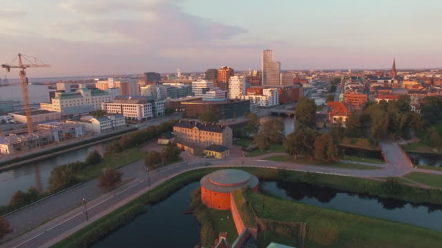 Luftaufnahme-über-Malmö-Stadtbild-bei-Sonnenuntergang-fliegen.-Drone-Schuss-von-\"Malmohus\"-in-Schweden,-Baustelle-und-Stadt-im-Hintergrund