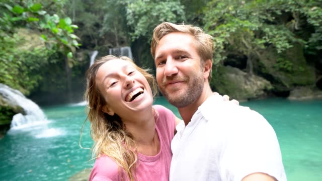 Junges-paar-unter-Selfie-Porträt-mit-einem-wunderschönen-Wasserfall