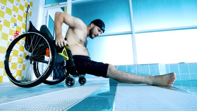 Behinderte-Mensch-wird-in-seinem-Rollstuhl-nach-dem-Aufstehen-aus-dem-Schwimmbad