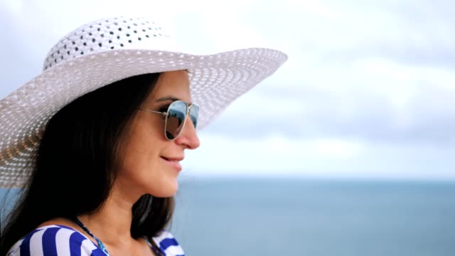 Nahaufnahme-Portrait-eines-lächelnden-schönen-weiblichen-Touristen-Hut-und-eine-Sonnenbrille,-entspannen-und-genießen
