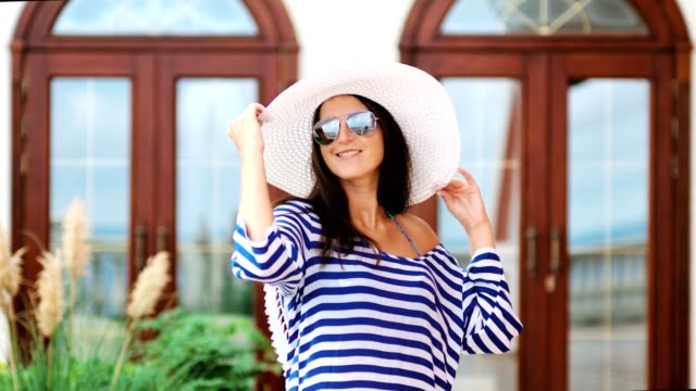 Schöne-weibliche-Touristen-in-Hut-Sonnenbrille-und-gestreiften-Kleid-Spaß-und-posiert