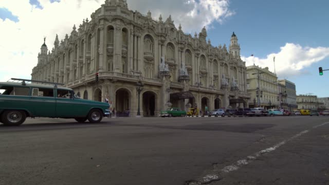 iconic-view-of-classic-american-1950s-cars-driving-on-main-street-in-Havana,-Cuba,-low-angle-shot