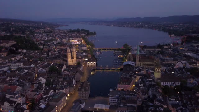 noche-iluminada-Zurich-centro-ciudad-orilla-del-lago-vista-aérea-panorama-4k-Suiza