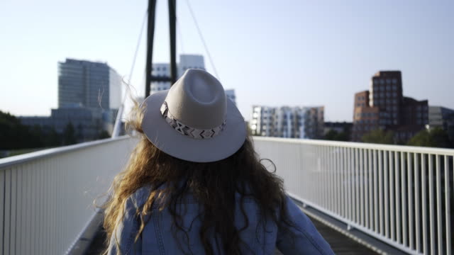 Mujer-caminando-sobre-el-puente-en-ciudad-moderna