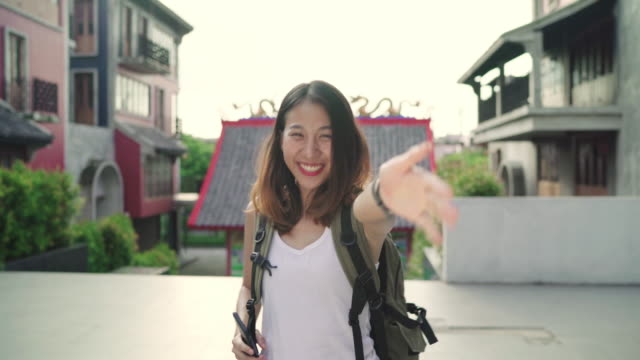 Asian-backpacker-woman-feeling-happy-traveling-in-Beijing,-China,-cheerful-beautiful-young-teenager-blogger-female-walking-at-Chinatown.-Lifestyle-backpack-tourist-travel-holiday-concept.