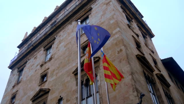Flaggen-der-Europäischen-Union,-Spaniens-und-Valencia-auf-den-verchromten-Fahnenstangen