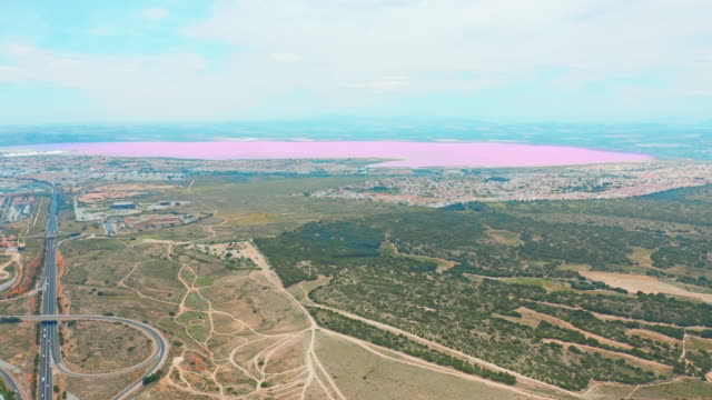 Panoramic-aerial-view-video-of-Las-Salinas,-bright-color-famous-place-pink-lake.-coastline-of-Torrevieja-city-and-Mediterranean-Sea.-Costa-Blanca.-Province-of-Alicante.-Spain