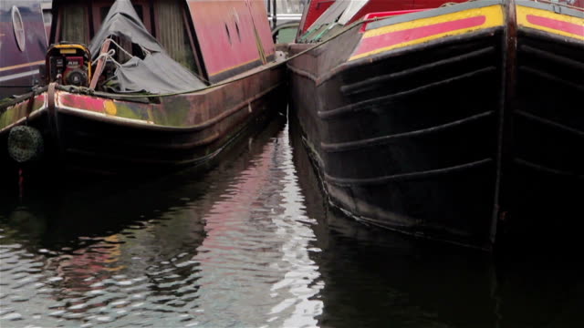 Tilt-To-Close-Up-of-Narrow-Boat-Barges-Docked-in-Canal-Harbor