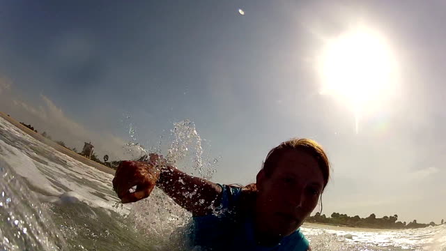 Surfer-girl-springt-auf-Wellen-und-beginnt-Paddeln