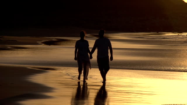 Couple-enjoying-romantic-walk-along-the-beach-in-silhouette,-Cape-Town,South-Africa