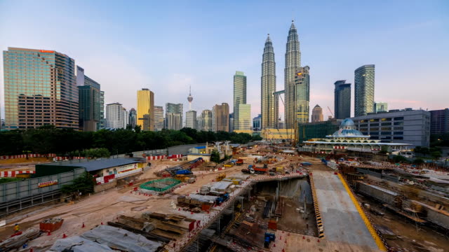 Sunrise-Time-lapse-de-construcción-con-vista-al-histórico-nacional,-las-torres-gemelas-Petronas-en-Kuala-Lumpur