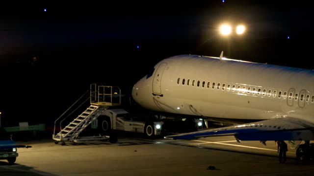 Avión-estacionado-en-la-noche-en-la-plataforma-de-lote