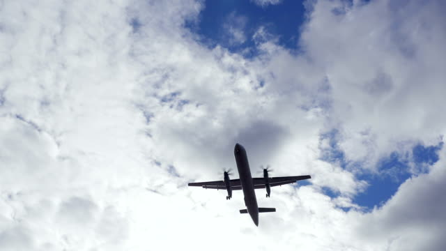 Commercial-Passenger-Airliner-during-Vertical-Overhead-Flyover-on-a-Sunny-Day-with-White-Clouds
