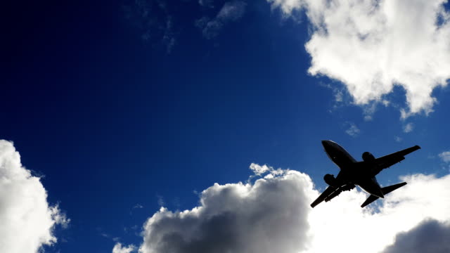 Kommerzielle-Verkehrsflugzeug-während-vertikale-Overhead-Überführung-an-einem-sonnigen-Tag-mit-weißen-Wolken