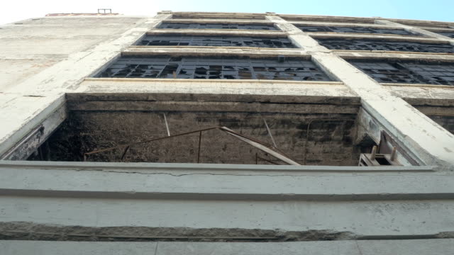 VISTA-de-ángulo-bajo:-Vidrios-rotos-de-las-ventanas-del-viejo-abandonaron-edificio-industrial