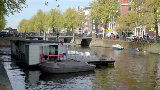 A-small-gray-boat-docking-on-the-side-of-the-floating-house