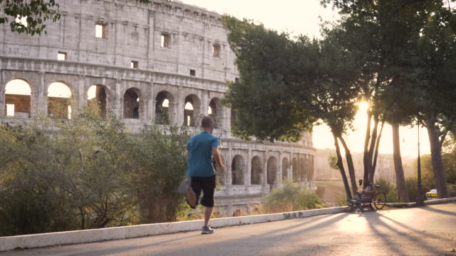 Mann-in-Sportbekleidung-laufen-vor-dem-Kolosseum-in-Rom-bei-Sonnenuntergang