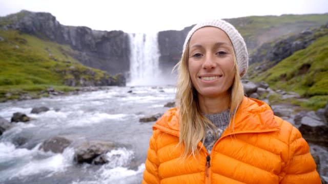 Porträt-von-blonden-Haaren-Frau-vor-der-herrlichen-Wasserfall-in-Island