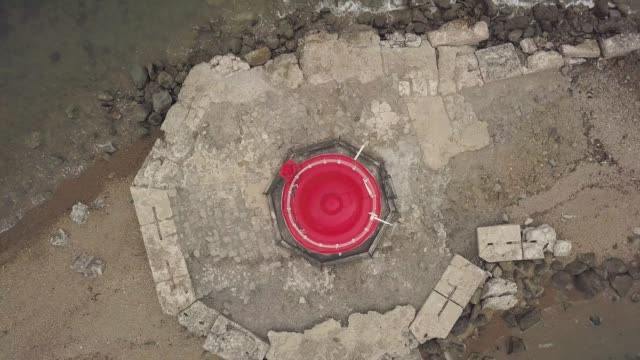 Drohne-Ansicht-oben-rote-Dach-des-Leuchtturm-am-Rand-am-Meer