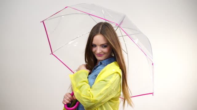 Woman-wearing-rainproof-coat-holding-umbrella-4K