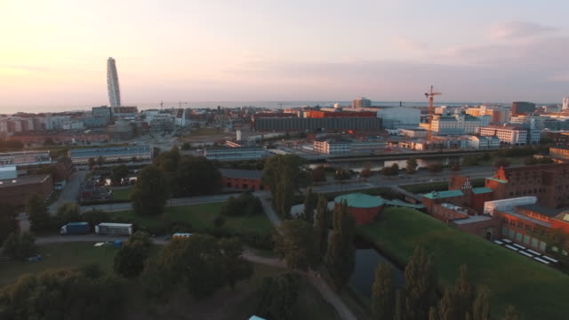 Aerial-shot-flying-down-over-Malmo-city-at-sunset.-Turning-Torso-building-in-the-background