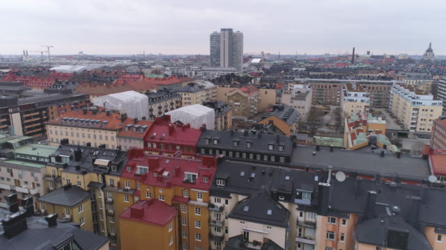 Drone-shot-over-city-buildings-in-Stockholm,-Sweden.-Aerial-view-of-Södermalm-district-rooftops-cityscape-skyline