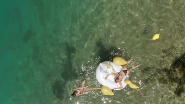 Aerial-view-of-woman-pulling-inflatable-with-friend-in-Panagopoula,-Greece.