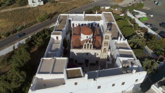 Aerial-view-of-Agios-Nikolaos-church-in-Spetses-next-to-a-road,-Greece.