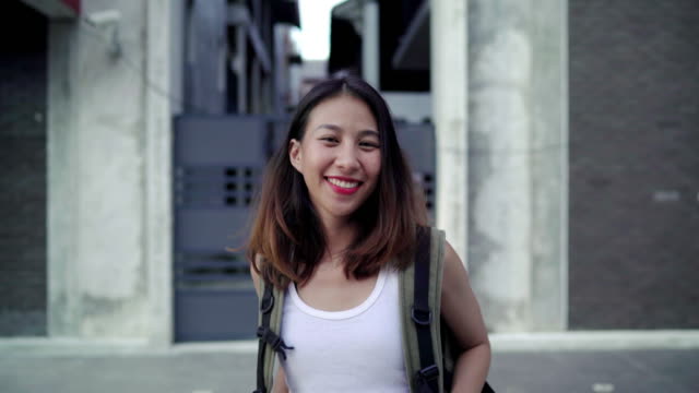 Asian-backpacker-woman-feeling-happy-traveling-in-Beijing,-China,-cheerful-beautiful-young-teenager-blogger-female-walking-at-Chinatown.-Lifestyle-backpack-tourist-travel-holiday-concept.