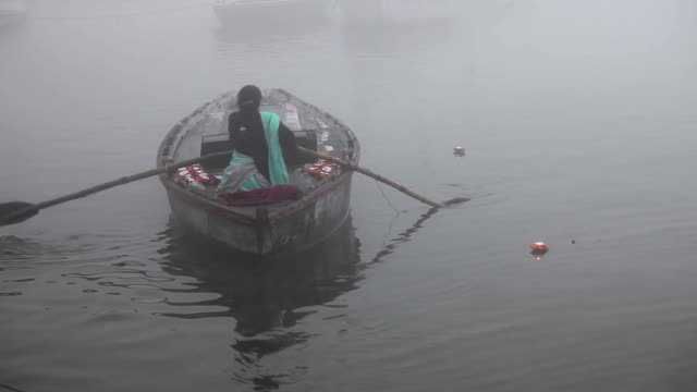 Mujer-en-barco-por-el-Ganges-de-flotación:-Varanasí,-India