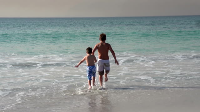 Dos-chicos-correr-en-el-mar,-la-Ciudad-del-Cabo,-Sudáfrica