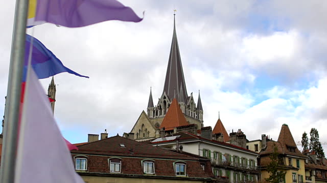 Coloridas-banderas-que-agitan-en-el-viento,-bonita-vista-de-la-Catedral-de-Lausana-Notre-Dame