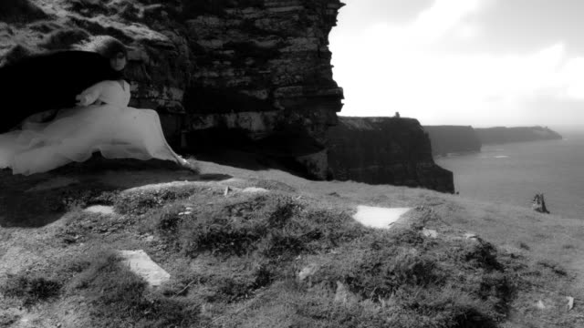 4k-Shot-of-a-Redhead-princess-on-Cliffs-of-Moher-View-in-Ireland,-black-&-white
