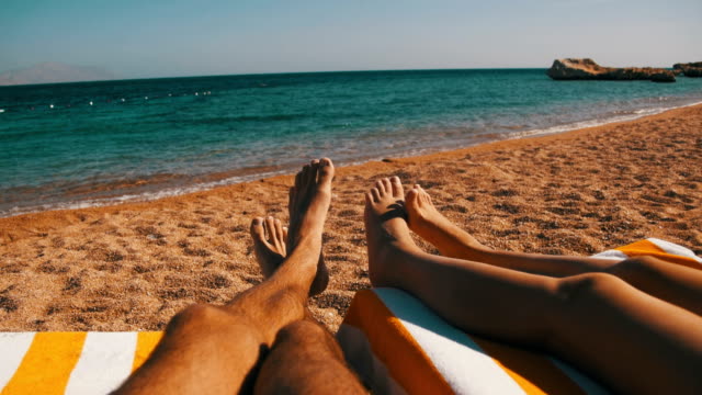 Beine-von-Paar-Menschen-liegen-auf-Strand-Sonnenliege-in-der-Nähe-des-Roten-Meeres