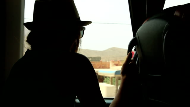 Junge-Frau-sucht-Trog-Fenster-und-spielen-mit-Händen-auf-Fond-im-Bus-während-der-Fahrt-sitzen
