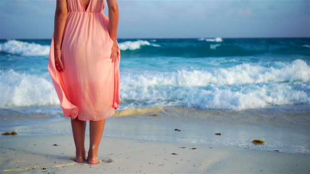 Beautiful-woman-on-white-beach.-Closeup-female-legs.-SLOW-MOTION