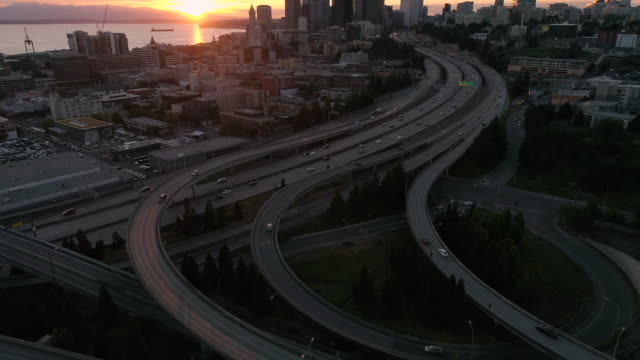 Sunset-Aerial-of-Interstate-5-in-Seattle,-Washington-with-Puget-Sound-and-Olympic-Mountain-Range