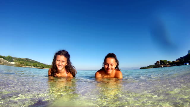 Glückliche-Mädchen-am-Sommerstrand-erfrischen-Sie-sich-im-türkisfarbenen-Meerwasser